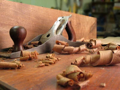 Hand plane and timber shavings on a carpenter’s workbench, from AJT’s existing website